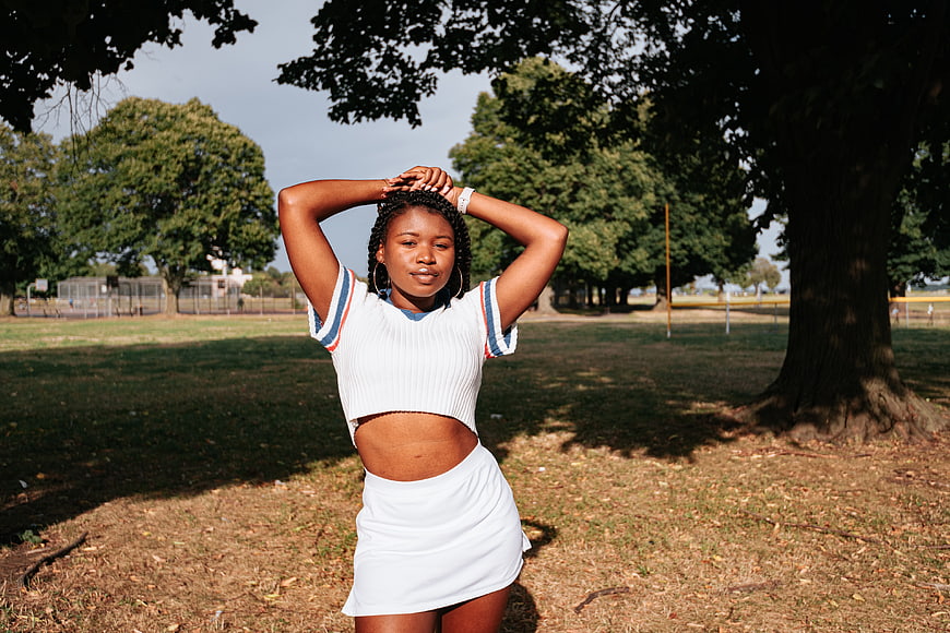 Confident Black Woman in White Outfit in Park
