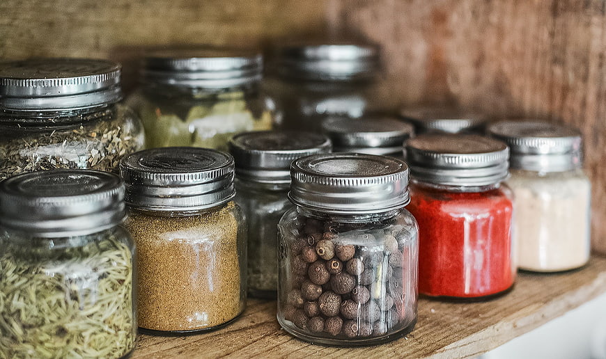 Assorted Spices in Glass Jars on Wooden Shelf