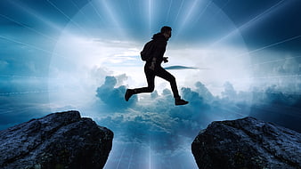Silhouette of man jumping between cliffs over clouds