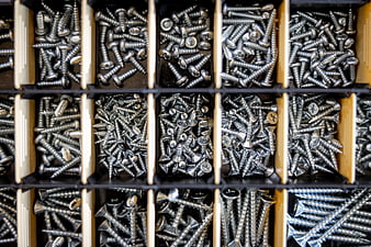 Organized assortment of metal screws in a storage box