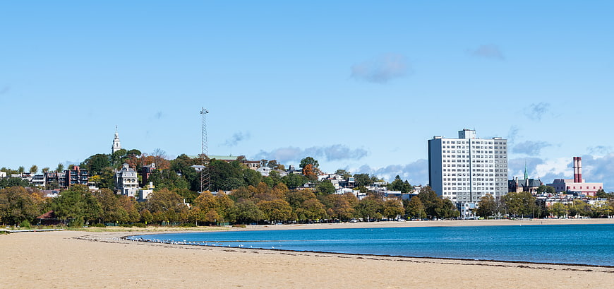 Coastal city skyline with sandy beach and blue water