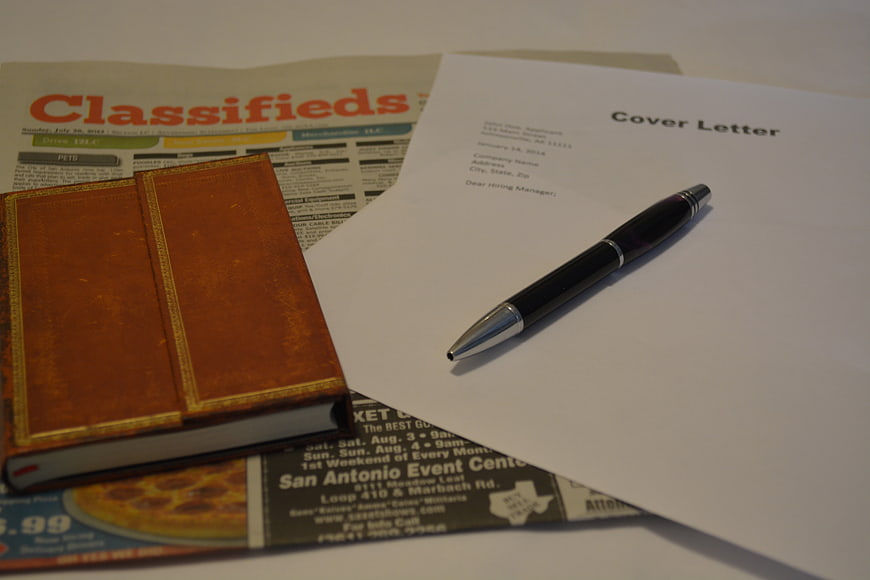 Job Application Cover Letter, Pen, and Resume on Newspaper Classifieds