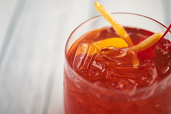 Close-up of Red Cocktail with Orange Peel and Cherry