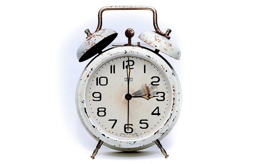 Vintage Rusty White Alarm Clock on White Background