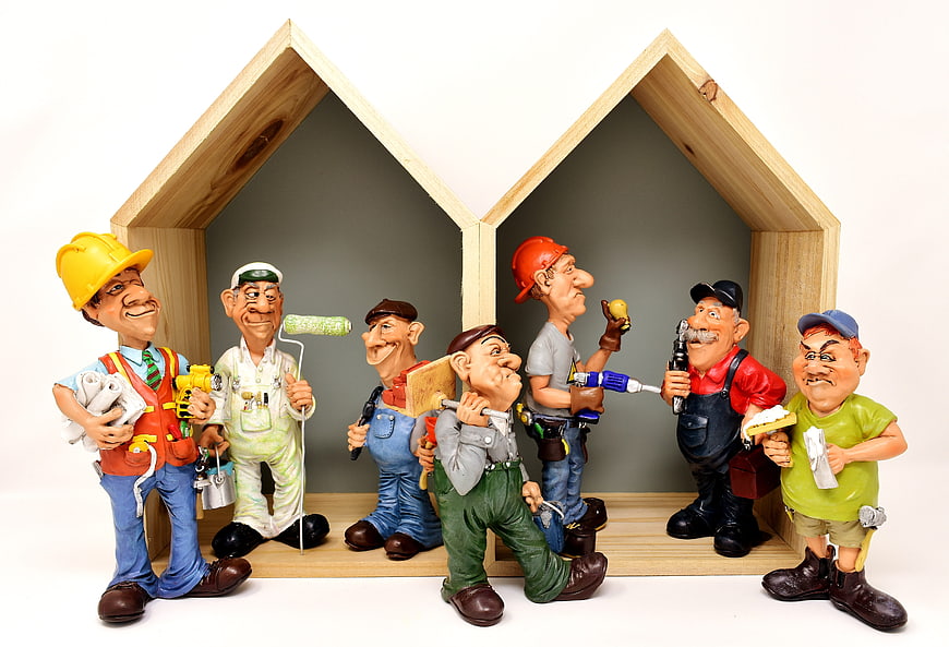 Cartoon Construction Worker Figurines in Wooden House Frame