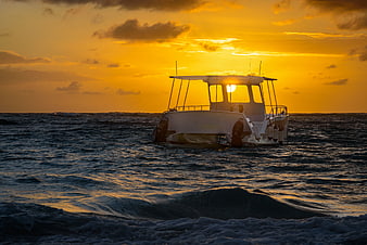 White Boat Silhouette on Ocean at Golden Sunset