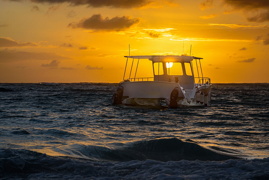 White Boat Silhouette on Ocean at Golden Sunset