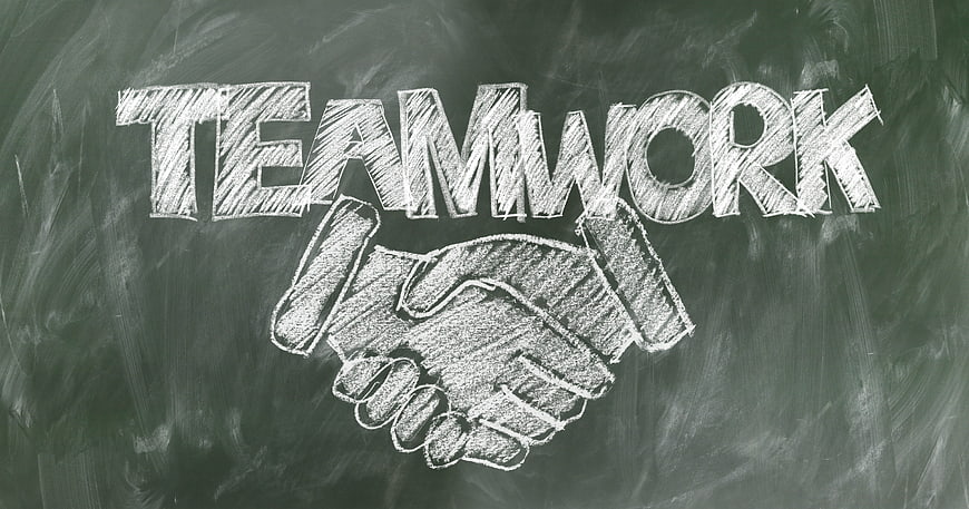 Teamwork chalk drawing with handshake on blackboard