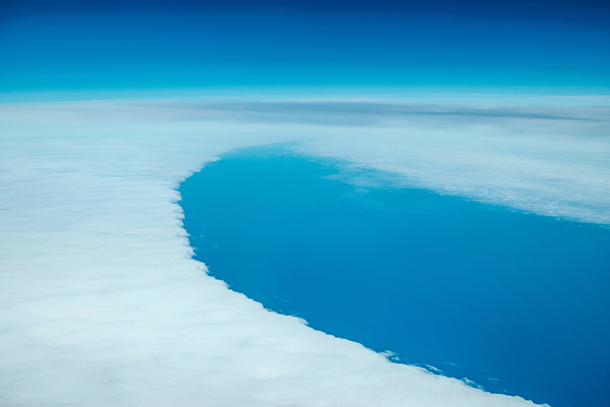 Aerial View of Blue Ocean Through Cloud Gap