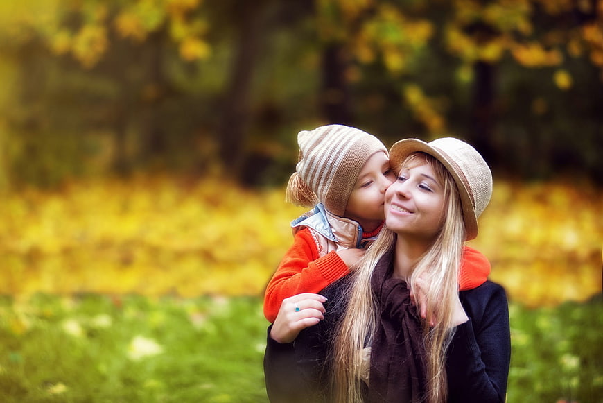 Mother and Child Kissing in Autumn Park