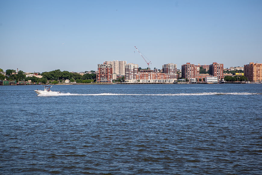 Motorboat Cruising on River with City Skyline Background