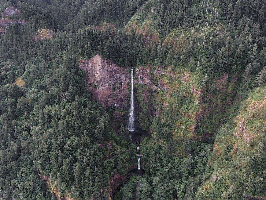 Aerial View of Tall Waterfall in Dense Green Forest