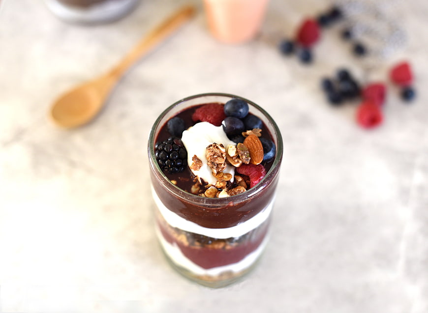 Overhead view of layered berry parfait with granola and yogurt