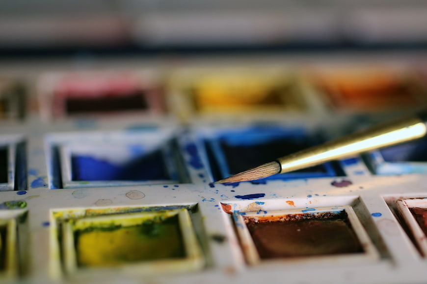 Close-up of watercolor palette with paintbrush