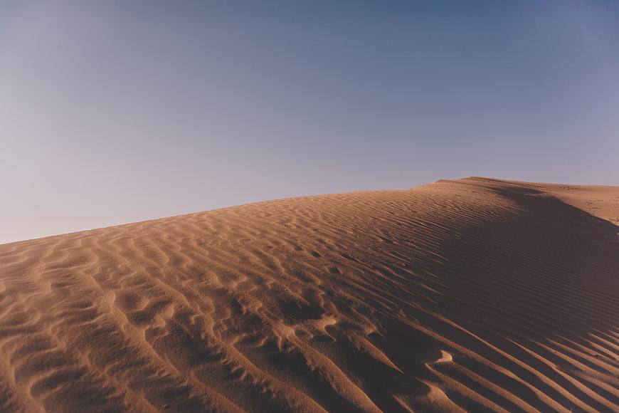 Golden Sand Dunes with Ripples Under Blue Sky