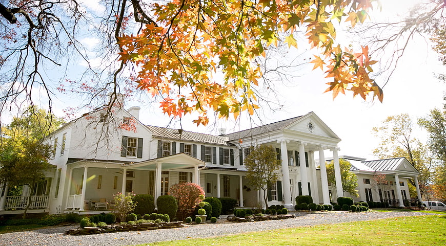 White Colonial House with Autumn Leaves and Columns