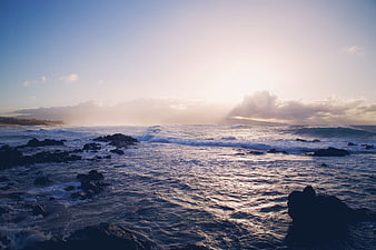 Dramatic Ocean Sunset with Sunbeams Over Rocky Coastline