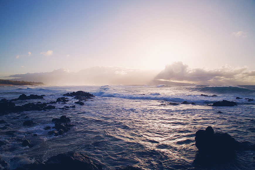 Dramatic Ocean Sunset with Sunbeams Over Rocky Coastline