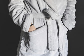 Person in White Plush Bathrobe with Hands in Pockets