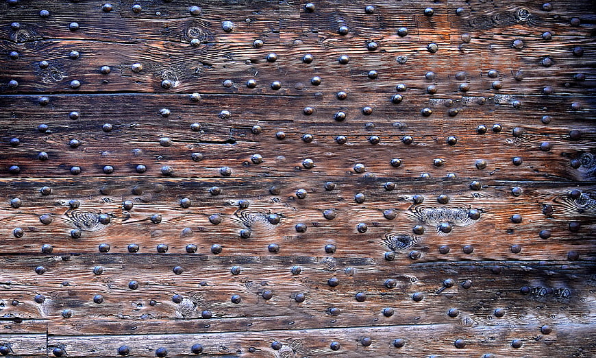 Textured Old Wooden Door with Iron Nails Background