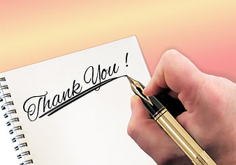 Hand Writing Thank You In Cursive On Spiral Notebook With Gold Pen