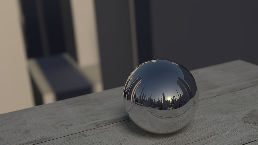 Reflective chrome sphere on wooden surface with city skyline reflection