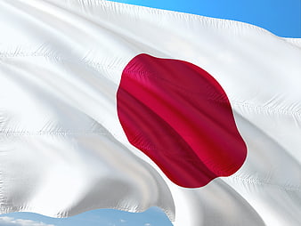 Waving Japanese Flag Against Blue Sky