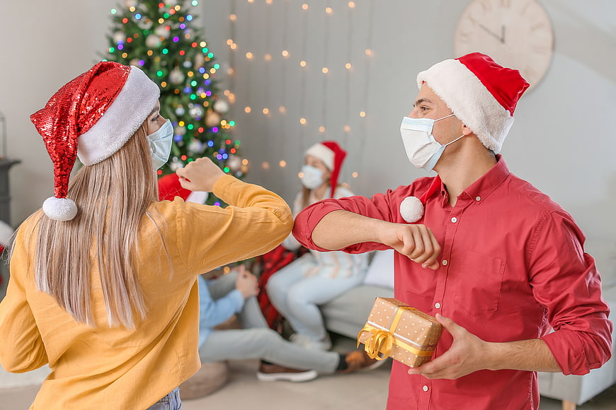 Family celebrating Christmas with face masks and elbow bump
