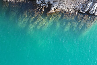 Aerial View of Turquoise Lake Water and Rocky Shoreline