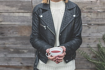 Woman in Leather Jacket Holding White Tea Cup