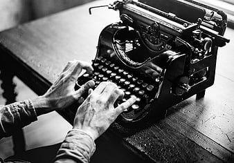 Hands Typing on Vintage Black and White Typewriter