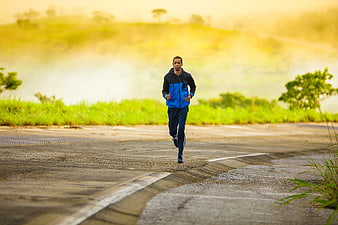 Man jogging on rural road at sunrise