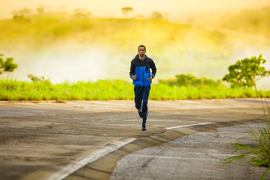 Man jogging on rural road at sunrise