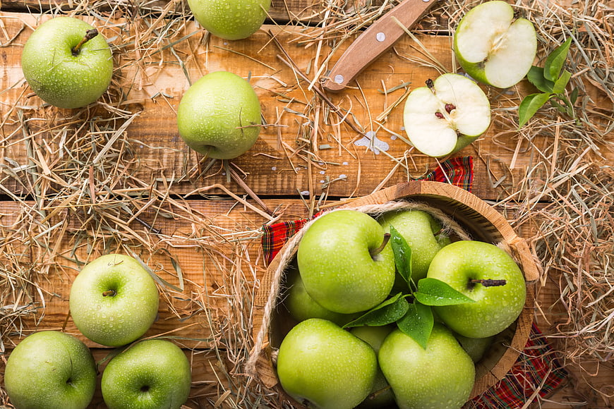 Fresh Green Apples in Wooden Bowl on Rustic Hay Background