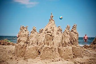 Detailed Sand Castle Sculpture on Sunny Beach with Blue Sky