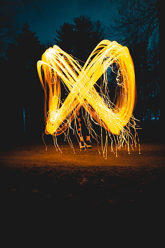 Steel wool spinning light painting infinity symbol at night