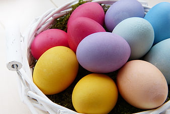 Colorful Easter Eggs in White Wicker Basket with Moss
