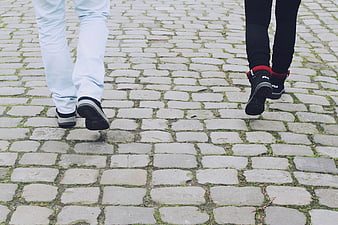 Couple Walking On Cobblestone Street