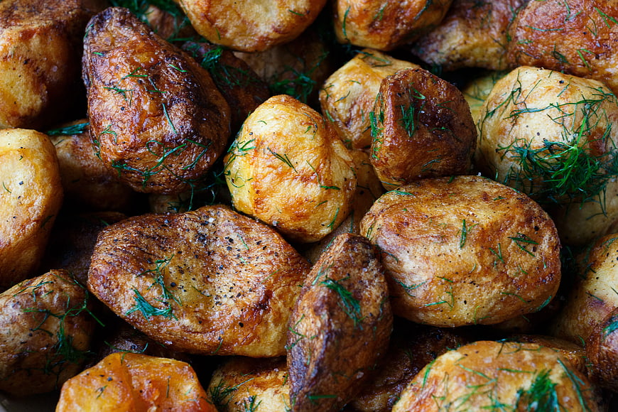 Close-up of roasted potatoes with fresh dill garnish