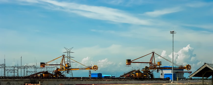 Yellow industrial cranes at construction site under blue sky