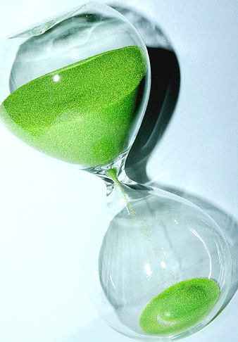 Green sand hourglass on white background