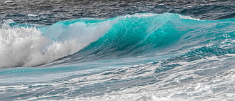 Powerful turquoise ocean wave crashing with white foam