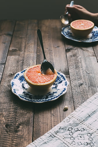 Halved grapefruit on vintage blue and white plate with spoon
