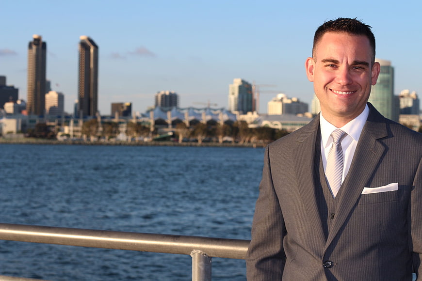 Smiling businessman in suit with city skyline background