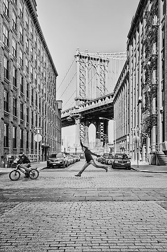 Man Jumping on Cobblestone Street in Dumbo, New York City