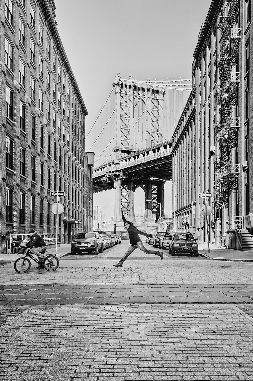 Man Jumping on Cobblestone Street in Dumbo, New York City