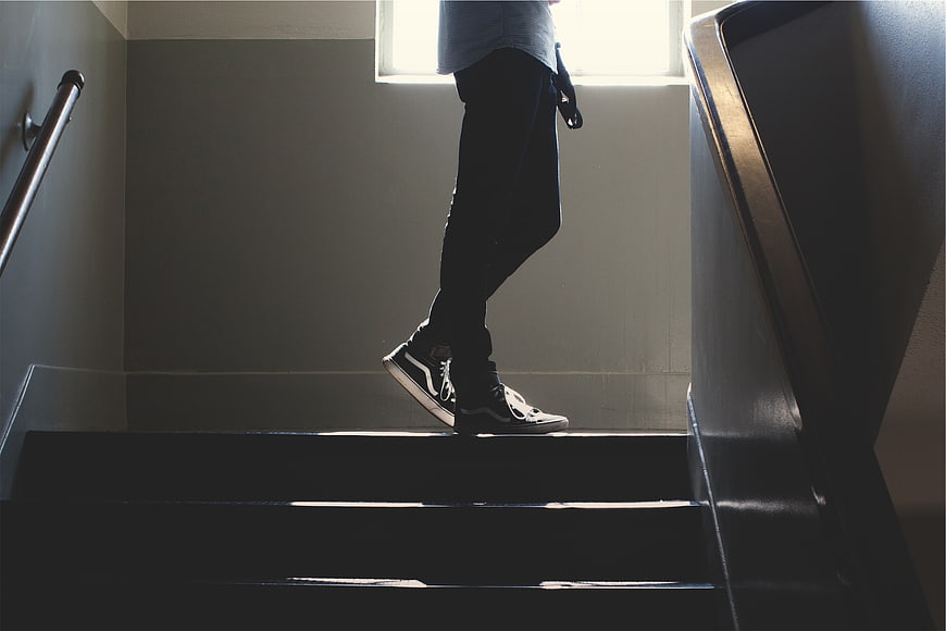 Low angle shot of man walking up stairs in sneakers