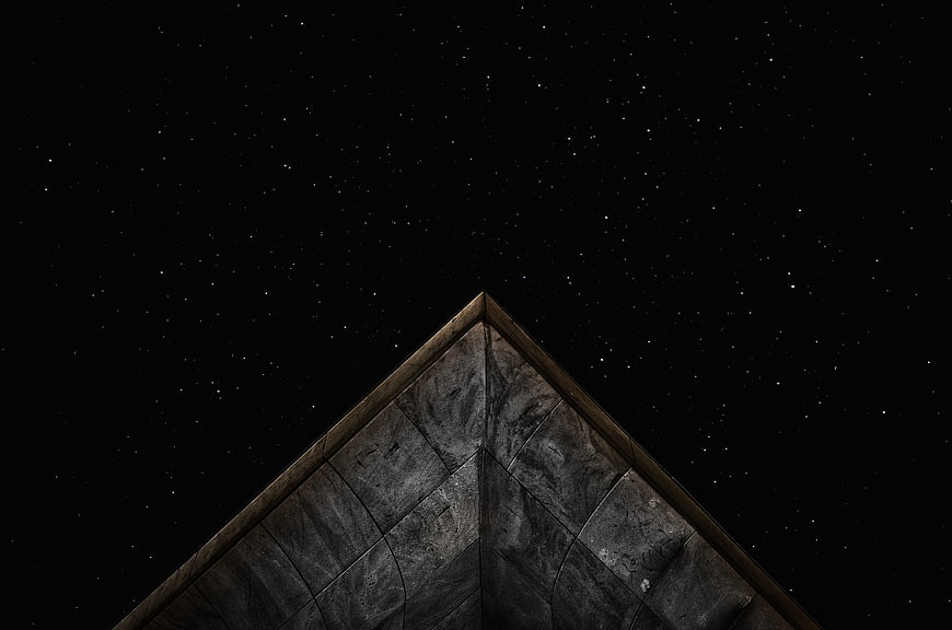 Starry Night Sky Above Geometric Stone Pyramid Roof
