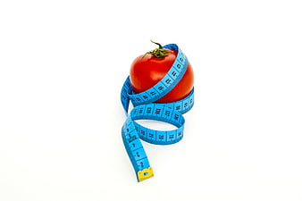 Red Tomato Wrapped in Blue Measuring Tape on White Background