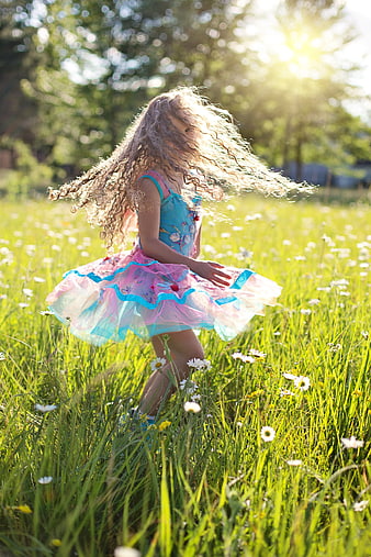 Little Girl in Pink Dress Spinning in Sunny Meadow